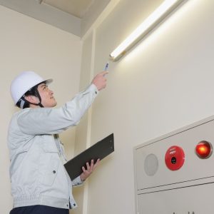 a condo inspector looking at a hallway light for compliances